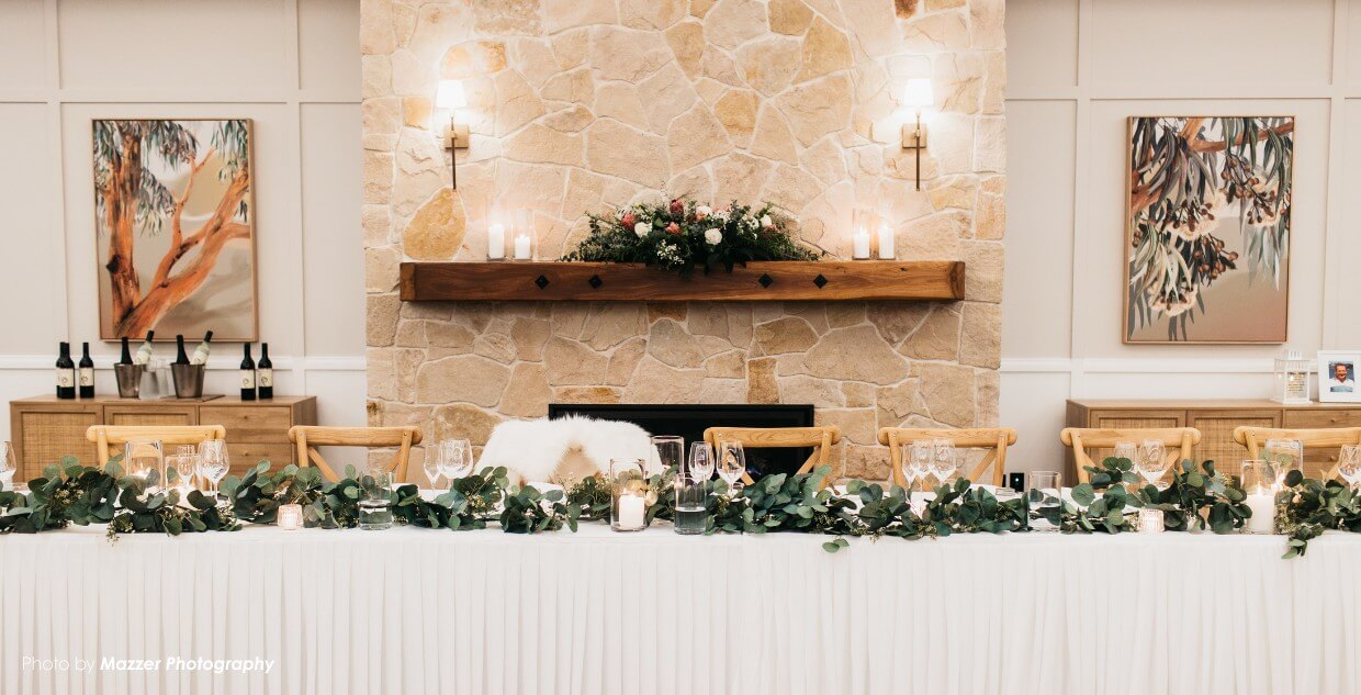 Elegant wedding reception table with greenery and candles.