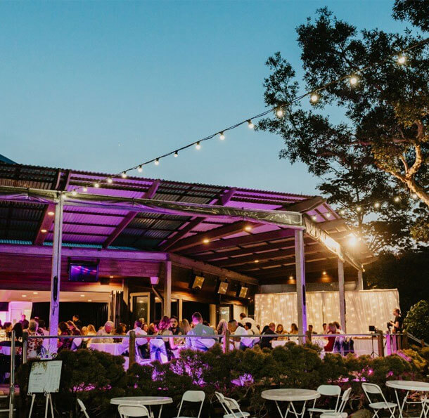 Outdoor event under string lights in the evening.