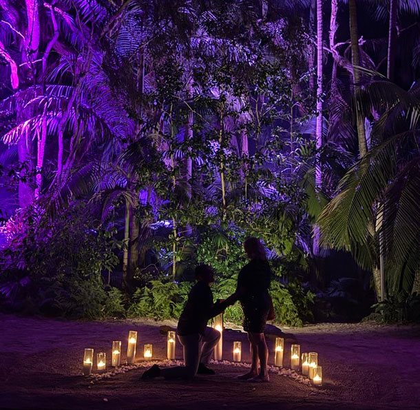 Couple standing in a circle of candles, during a proposal