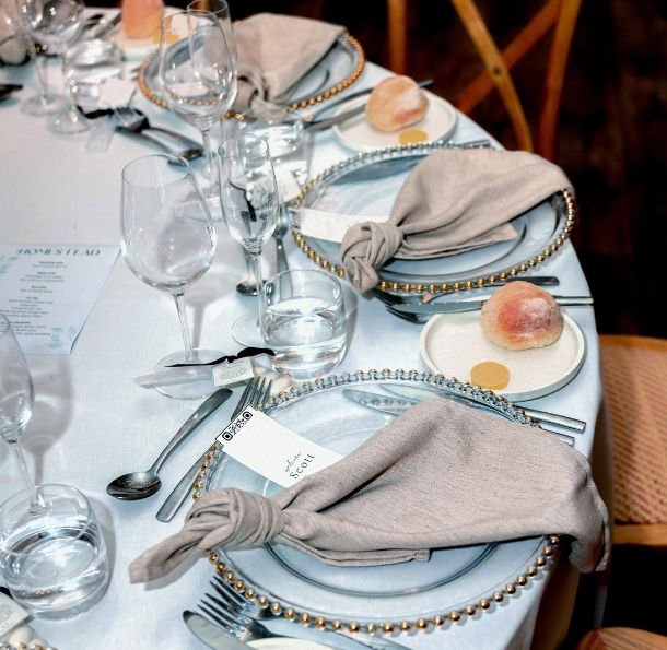 A beautiful wedding table set with neutral colour napkins, tableware and bread and butter starters