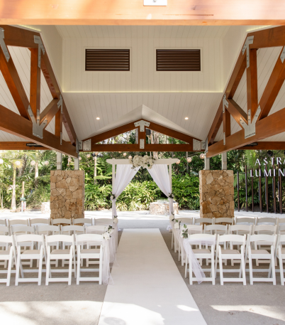 Elegant wedding reception set up at an undercover rustic outdoors venue with greenery surrounding it