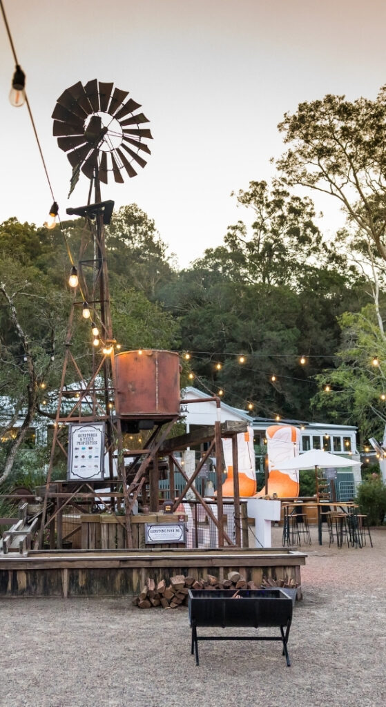 Outback Springs event venue at dusk featuring windmill, string lights and outdoor seating